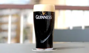 Un bicchiere di birra scura irlandese Guinness, con la sua iconica schiuma cremosa, pronto per essere gustato.