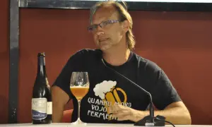 Uomo con bicchiere e bottiglia di birra artigianale, con maglietta che recita "Quando moro vojo fermentare". Non è birra industriale, ma passione!