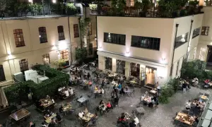 Serata vivace al birrificio La Piazza, con tavoli all'aperto pieni di gente che gode della buona compagnia e delle birre artigianali.