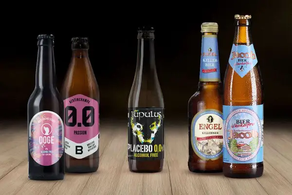 Cinque bottiglie di birra analcolica, tra cui Doge, Bertinchamps 0.0, Lupulus Placebo, Engel e Jacob. Le migliori birre analcoliche per ogni occasione.