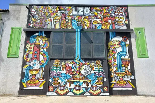 Mural colorato con il nome "LZO Brewery" in alto, raffigurante creature fantastiche, cascate e simboli.