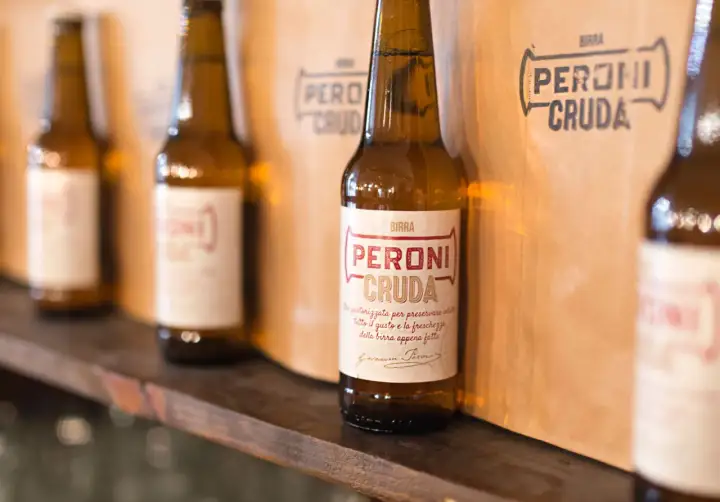 Bottiglie di birra Peroni Cruda, non pastorizzata per preservare tutto il gusto e la freschezza. Il significato di "cruda" è proprio questo: freschezza autentica.